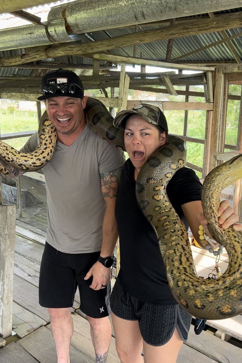 Two team members holding a large snake on a rest day