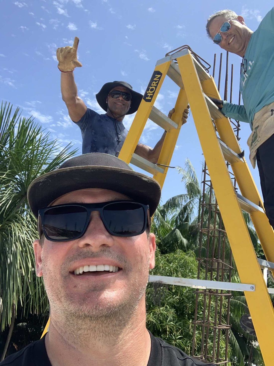 Team members working from a stepladder on a build site