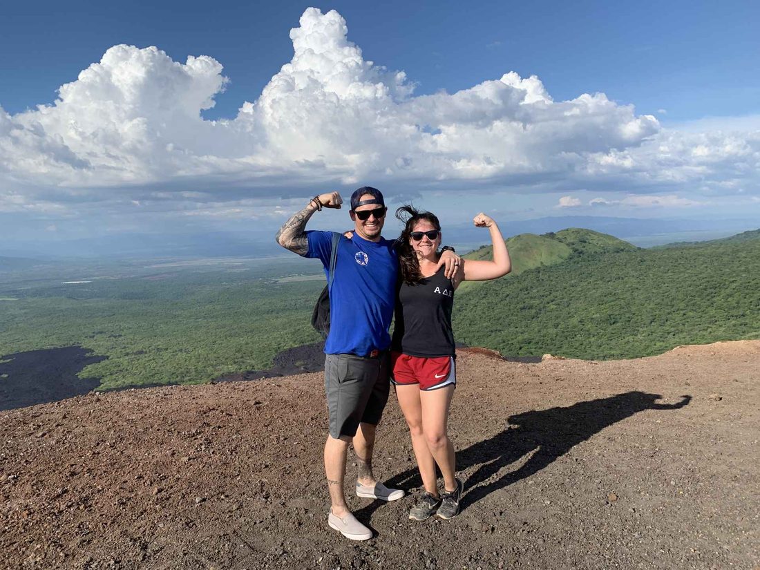 Two team members on a hilltop overlooking the valley