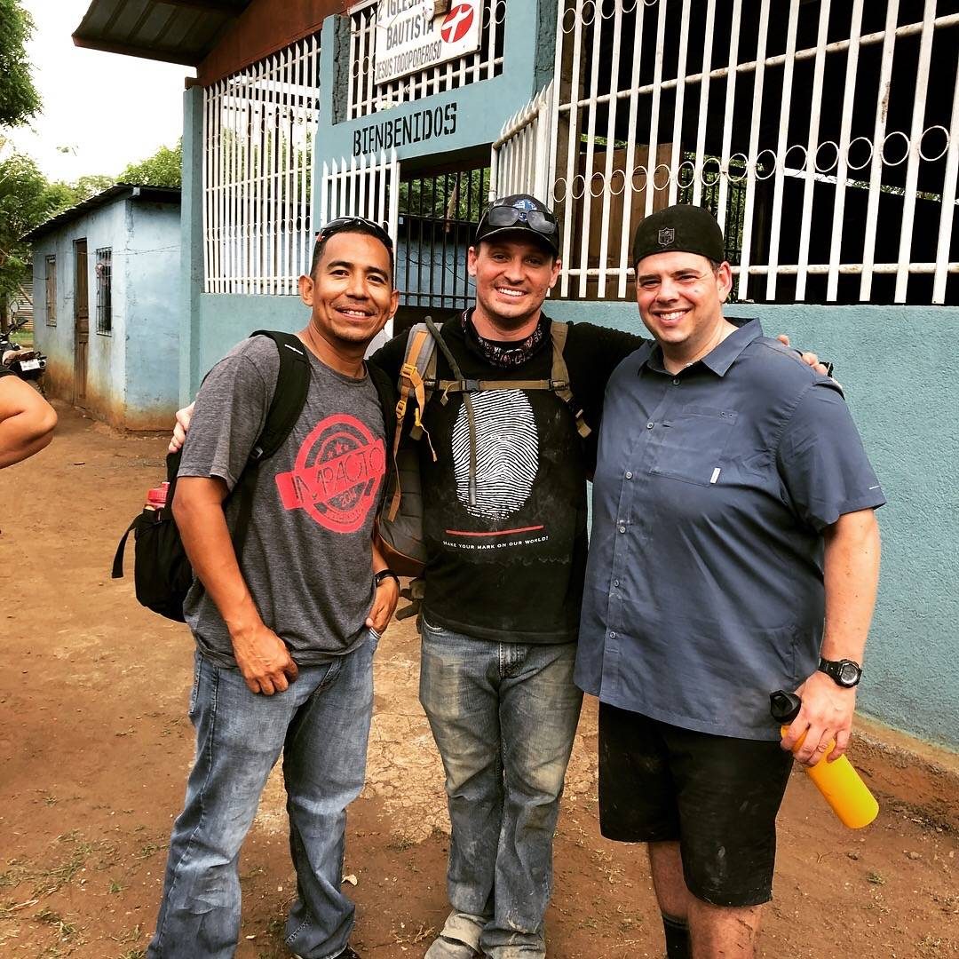Three team members outside a local Baptist church