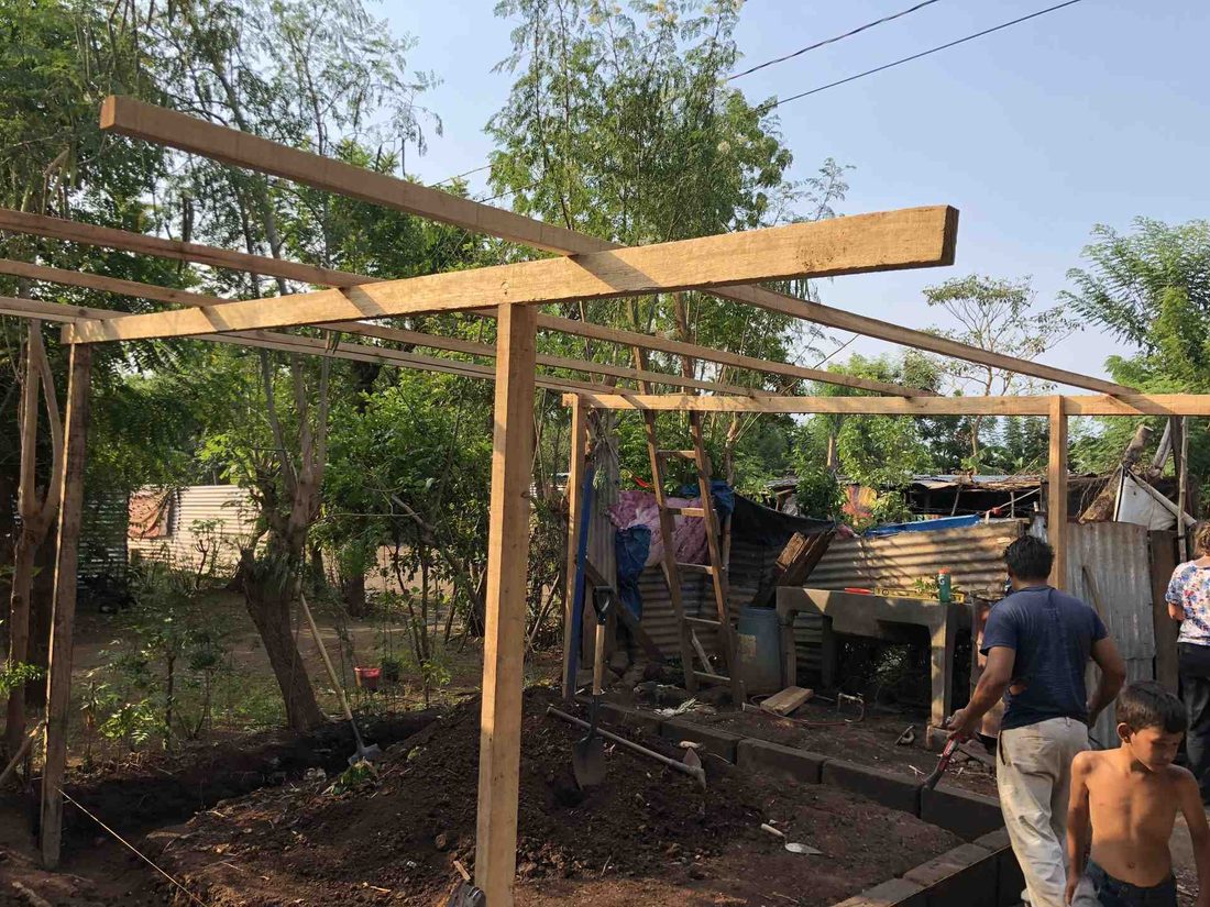 Volunteers raising the timber frame of a new structure