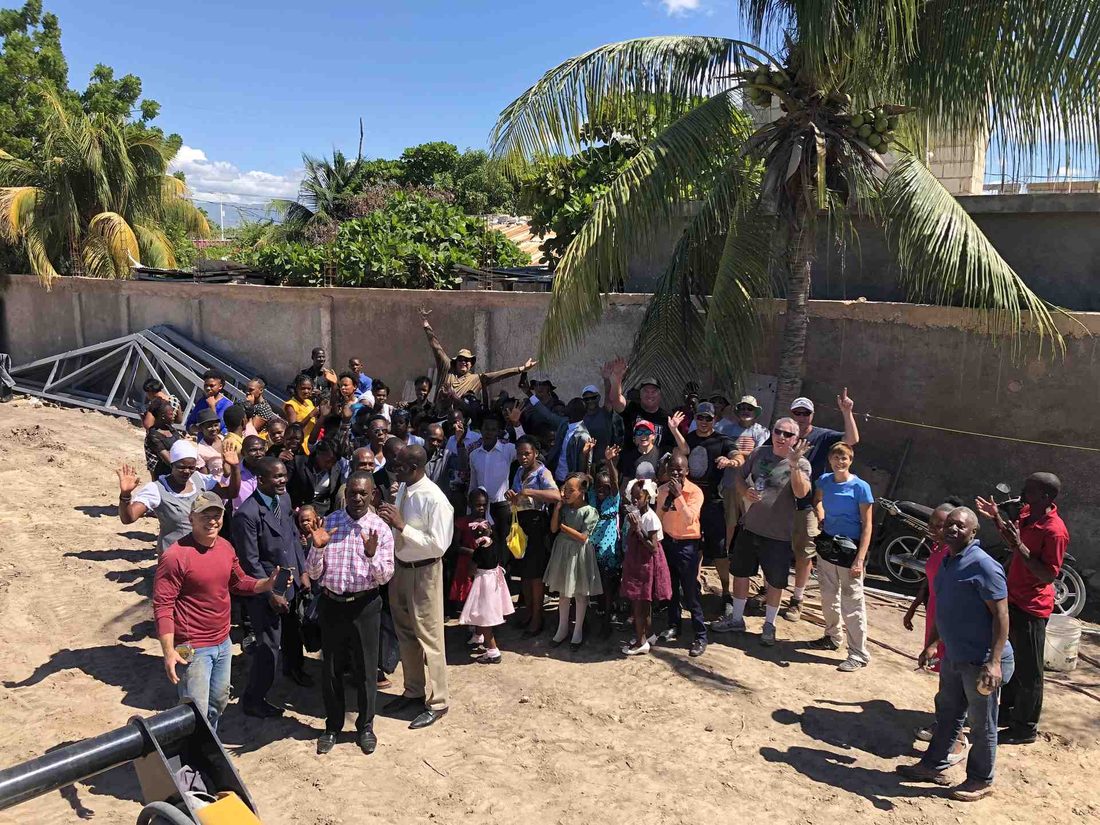 The team and members of the local community gathered together at a build site