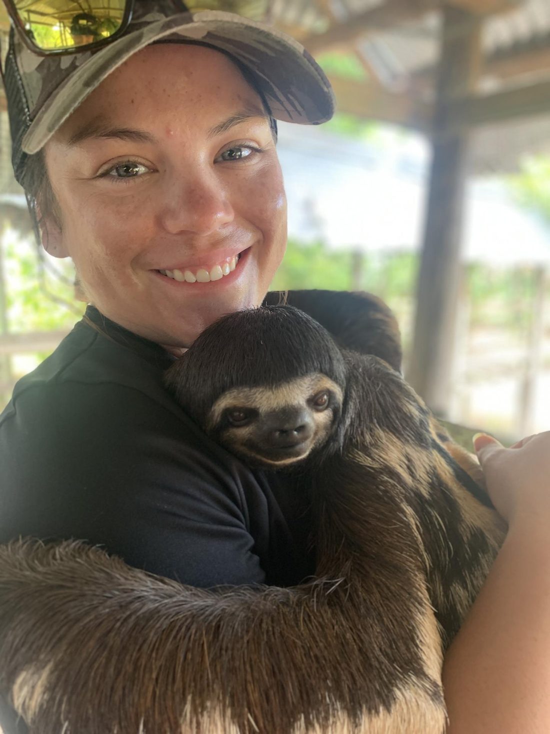 A team member holding a sloth on a rest day